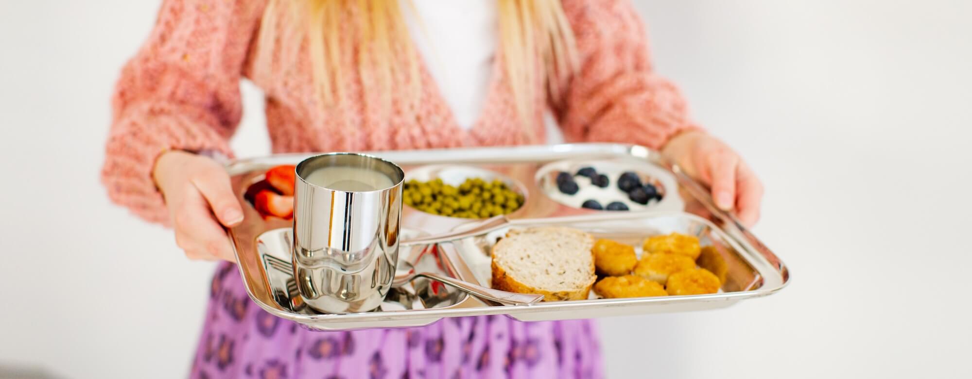 child with stainless steel cafeteria tray