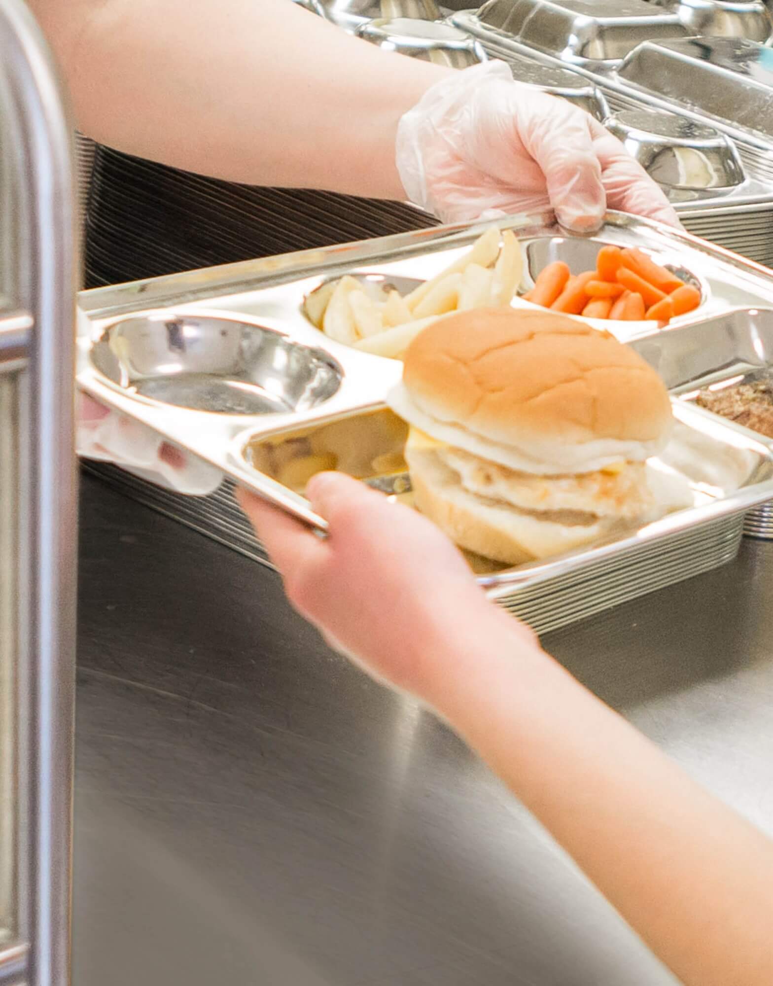 stainless steel cafeteria tray being served in cafeteria